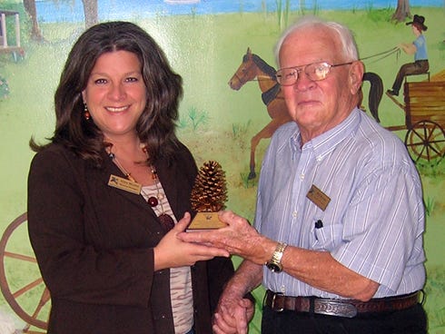 The Heritage Museum of Northwest Florida’s Gina Marini presents the 2012 Kenneth E. Bailey Presentation and Stewardship Award to longtime trustee Bill Reeder.