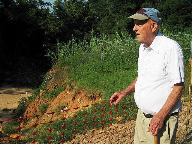 Environmentalist John McMahon surveys a gully off Gil-Ava Street that produced tons of soil and debris that washed onto his adjacent property.