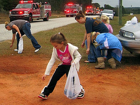 Children and adults pick up candy on New Ebenezer Road during the 2012 Laurel Hill Christmas Parade. This year's parade is 3 p.m. Saturday.