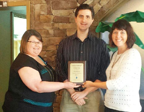 Covenant Care communications manager Paula White, left, and development manager Rachel Mayew present a plaque to Crestview News Bulletin Editor Thomas Boni on Monday at the Arirang restaurant in Crestview. Boni is among the nonprofit's seven Covenant Care Media Society inductees for 2015.
