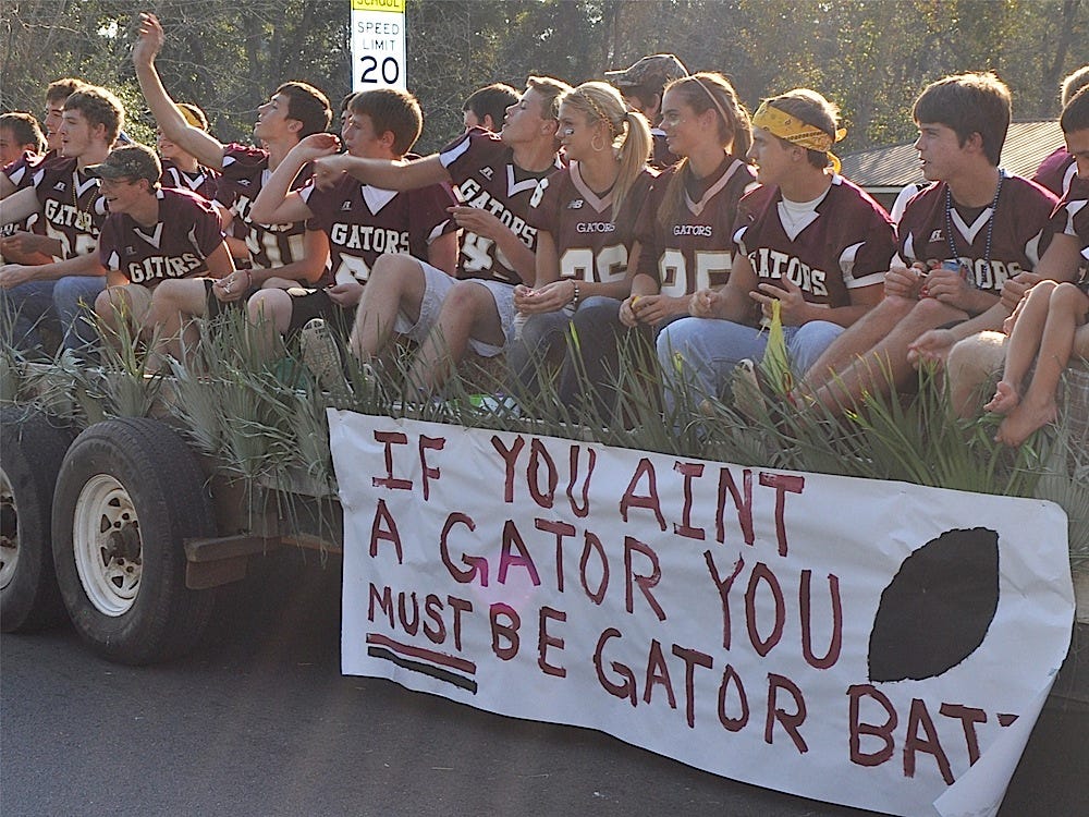 Baker High School’s varsity football team members throw candy from a float during Friday's homecoming parade. The team won the homecoming game against Sneads, 28-14.