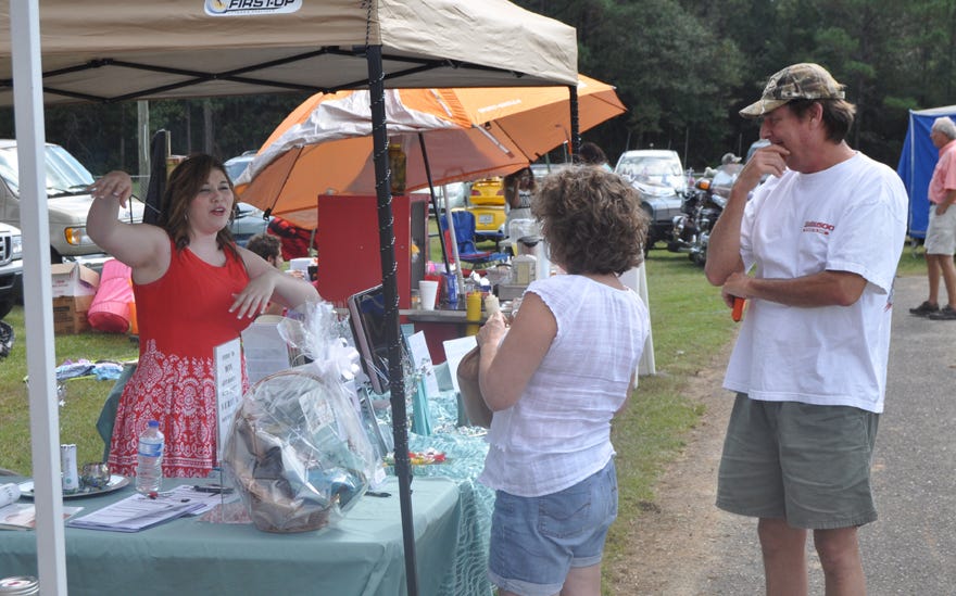 Alyssa Padget, a Nerium Skin Care consultant, chats with Patti Thornhill and John Stillwell during the Laurel Hill Fall Festival on Saturday at Gene Clary Park.