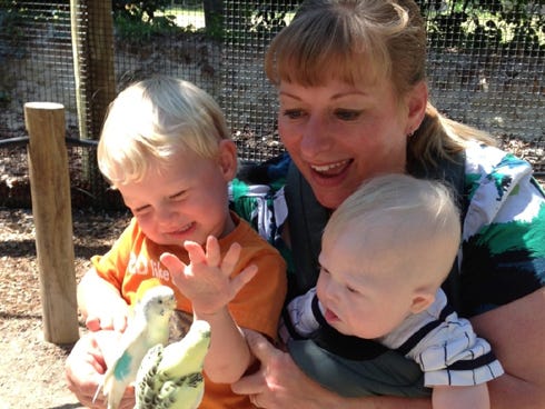 Stefanie Shea introduces her sons Logan, 2, and Benjamin to colorful birds during a family zoo outing.