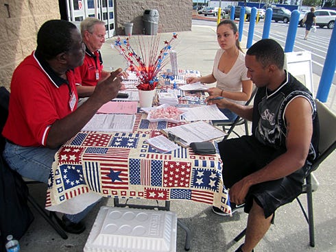 Fletcher Williams and Ed Kitchen help Julia and Michael Gaskins change their address on their voter records.