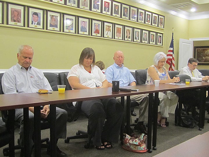 Community leaders pause for a moment of silence in remembrance of 9/11 victims. From left are Crestview Area Chamber of Commerce President Dennis Mitchell, former president Karen Hardell, business leader Cliff Calderwood, former city councilwoman Linda Parker and Mayor David Cadle.