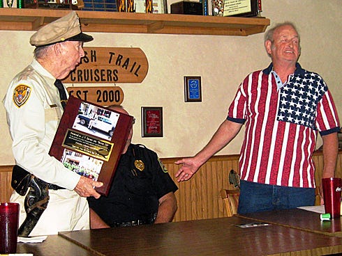 J.T. Garrett, uniformed as TV's Deputy Barney Fife, accepts a lifetime membership in the Spanish Trail Cruisers Car Club from club member Danny Tate.