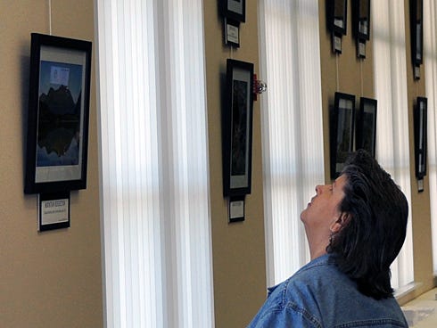 Lisa Bean of Crestview eyes the Crestview Photo Club's first exhibition at the Crestview Public Library. The exhibition closes Feb. 28.