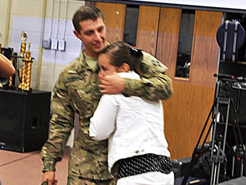 Army Pfc. Davis Schmitz surprises his sister, Karly Celano, in her Crestview High School band class upon returning early from deployment in Afghanistan.