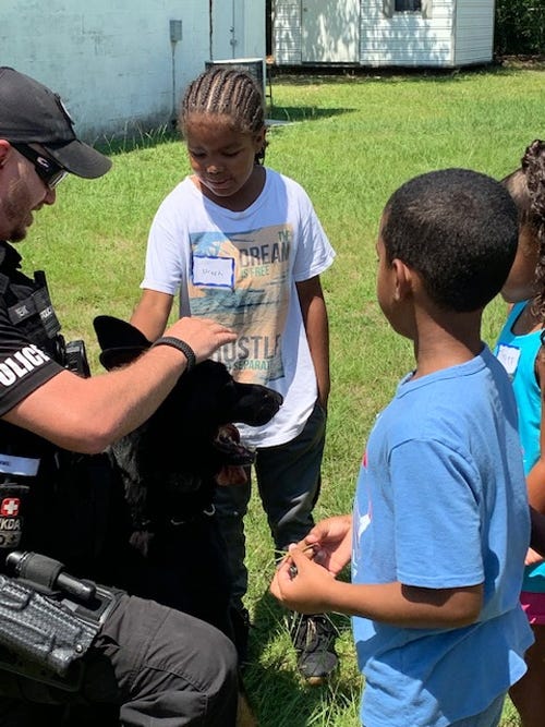 Uriah, 8, and other children chat with Officer Jay Peak and K-9 Sonic of the Crestview Police Department during Library Class at Mt. Zion A.M.E. Church in Crestview. [CONTRIBUTED PHOTO]