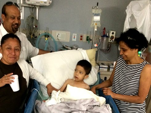 Julio Chi, a 4-year-old from Orange Walk, Belize, recovers from Friday morning surgery. His mother, Angelica; pediatrician, Crestview's Dr. Joseph Peter, and Peter's wife, Bernadine, flank him.