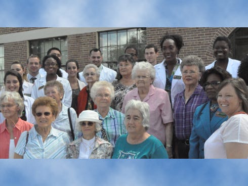 Women who worked in the Alatex building when it was a sewing factory, and the first class of students at FAMU Rural Diversity Healthcare Center, pose for a photo.