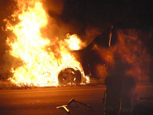Flames pour out of the front of an SUV on the shoulder of the northbound lanes of State Road 85 in Crestview near the P.J. Adams Parkway intersection.