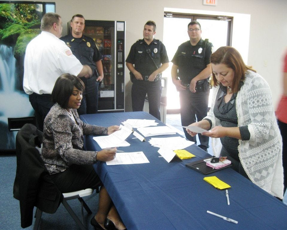 Crestview mayoral assistant Zee Richardson helps resident Erica Teets register to speak during Monday's City Council meeting at which the status of the Confederate battle flag in Confederate Park was an agenda item.
