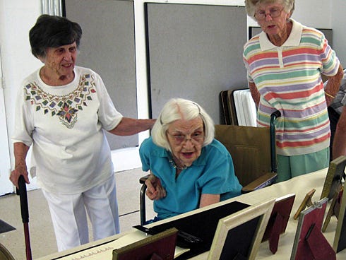 McDonald Campbell reminisces on Saturday while eyeing photos from her past 100 years with family members Mary Will Crook and Bertie Ann Curenton.