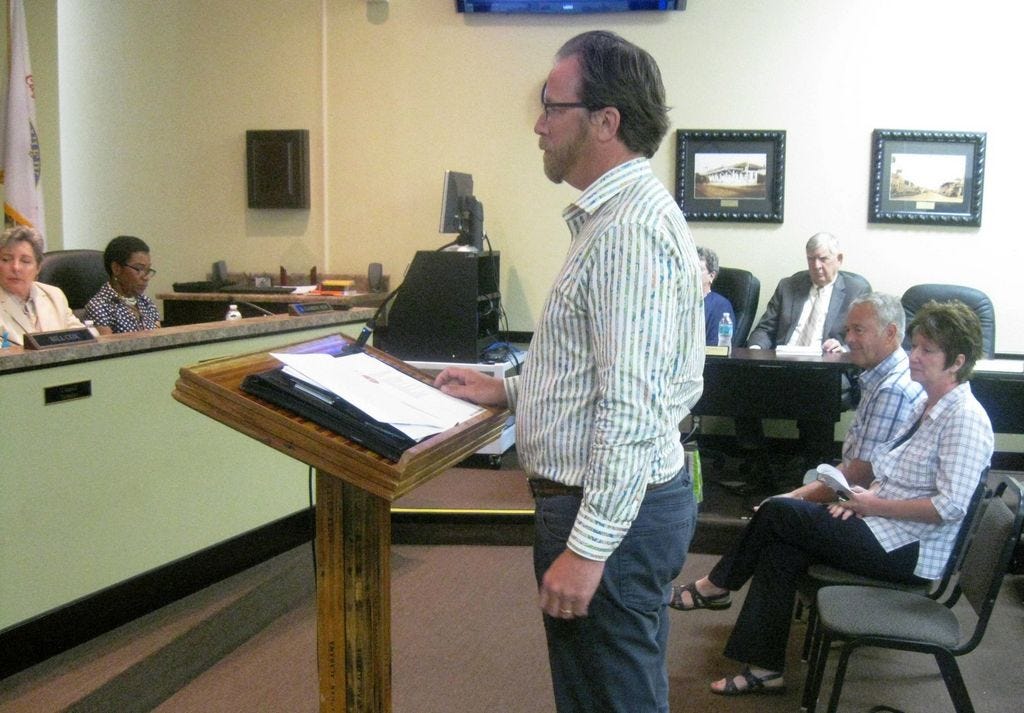 Stephen Smith, senior account executive with the Petermann Agency, describes his firm's expertise to the Community Redevelopment Agency Board as the agency's team leader, outgoing CRA Director Brenda Smith, observes.