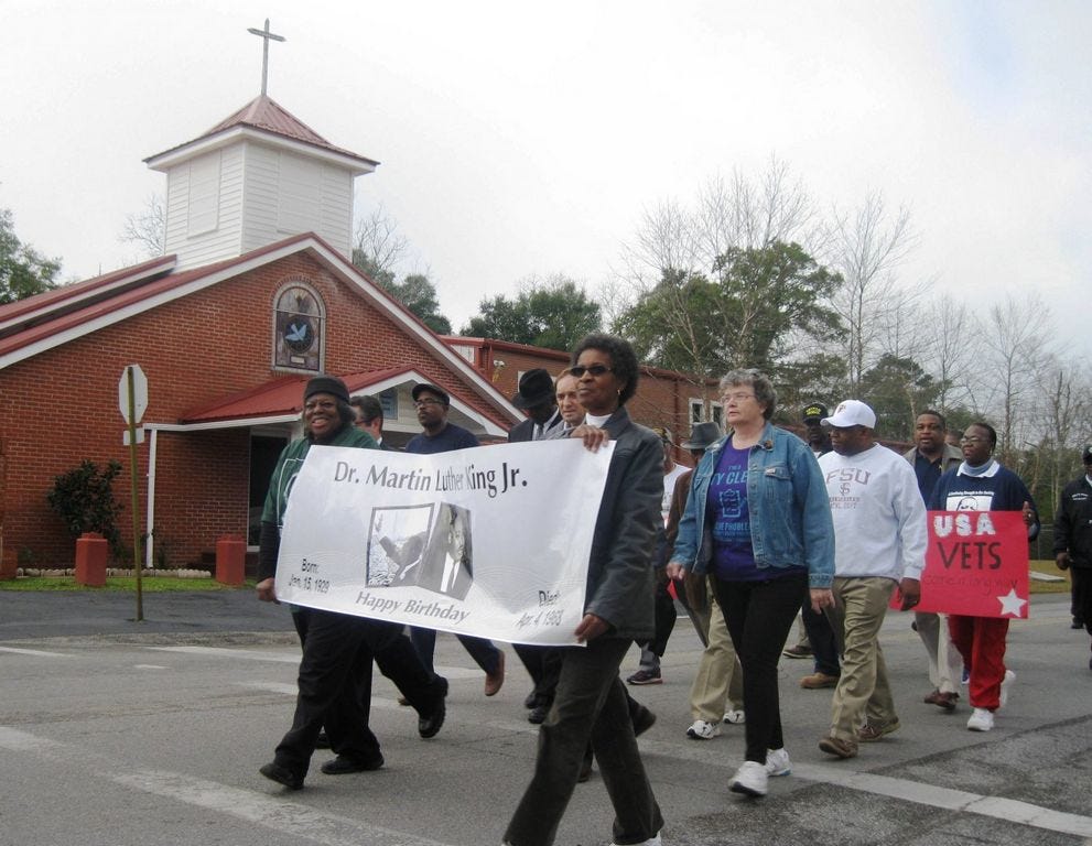 The nearly 30 people who joined the Concerned Citizens group's Jan. 16 march commemorating the works of the Rev. Martin Luther King Jr. process past Macedonia Missionary Baptist Church.