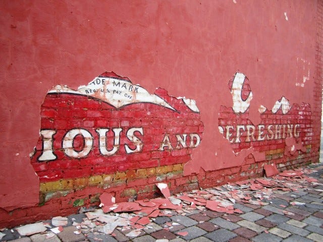 Stucco chipping from the side of Granny's Attic on Main Street has revealed a hand-painted Coca-Cola advertisement that may date back to the 1920s.