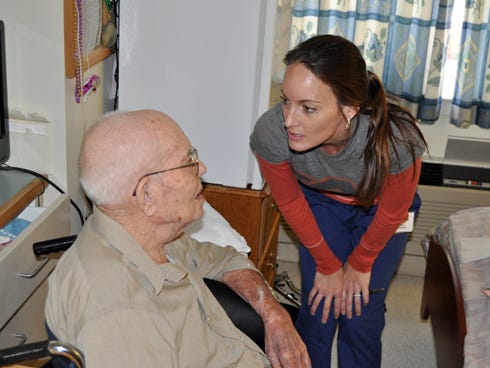 Amanda Owens, Shoal Creek Rehabilitation Center’s activities director, talks with Willie "Paw-Paw" Sanford, one of three 100-year-old residents at the facility.