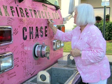 Crestview resident Linda Parker inscribes a message commemorating her late parents, who had cancer, on “Chase,” a Jacksonville-based Pink Heals Tour firetruck.