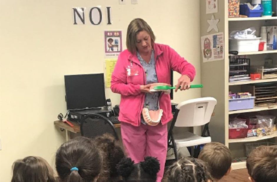 Laura Blocker, dental assistant at the Florida Department of Health in Okaloosa County, provides a demonstration to the students of The Children's Center on how to brush teeth properly recently in Fort Walton Beach.