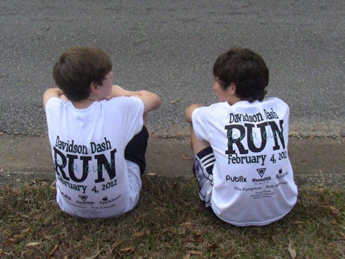 Two participants sit while displaying their Davidson Dash Run for a Cure T-shirts at a previous Relay for Life event. The Relay for Life event, set for 8:30 a.m. Saturday at the school, will raise money for the American Cancer Society.