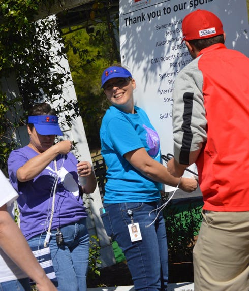 CHELCO employees get ready for the company's first charity golf tournament April 8 in Mossy Head. Pictured from left are Luann Schley, Susan Sanders and Blackstone Golf Course club manager Will Hutchinson.