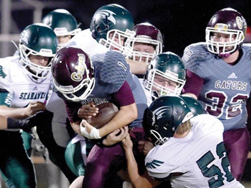 Baker School's Austin Davis runs for yardage against a mob of South Walton defenders on Oct. 9. The Gators will face another physical opponent Friday, when they travel to Chipley to take on the Tigers.