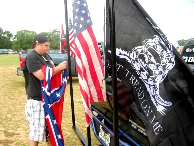 Jake Moore fastens the Confederate battle flag to a custom flag pole attached to his trailer hitch in preparation for Saturday's Southern Strong convoy and rally, which departed Crestview's Old Spanish Trail Park.