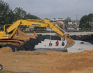 A new downtown parking lot will be close to City Hall (rear, behind steam shovel) and FAMU Rural Diversity Healthcare Center in the Alatex Building (right rear).