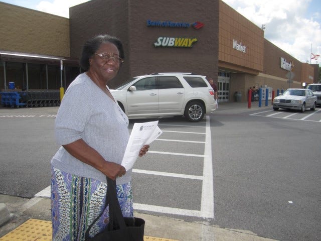 Community activist Mae Reatha Coleman, grasping a letter of authorization from Mayor David Cadle, heads into the Crestview Wal-Mart to solicit corporate support for the city's bus routes.