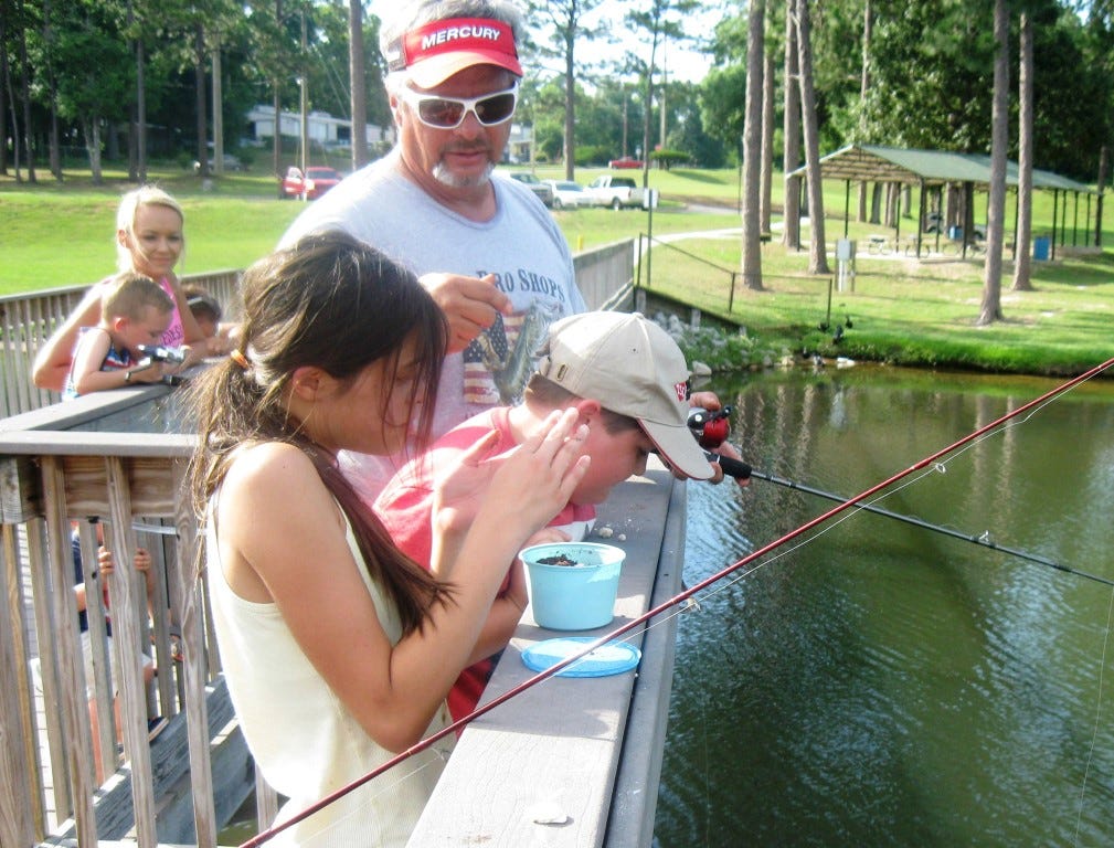 Crestview High Outdoor Education teacher Ernie Martin shares fishing advice and stories with fishing camp students Bryce Clark and Trevor Franklin Hayes.