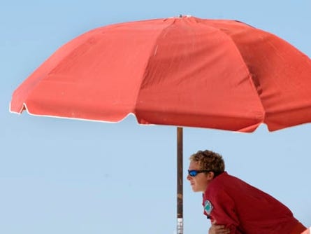 A lifeguard scans the beach behind The Boardwalk on Okaloosa Island. A report issued this week by the state Auditor General David W. Martin said Okaloosa County’s use of bed tax revenue to pay for beach patrols, lifeguards and a beach shuttle is not allowed under state law.