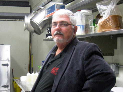 Buddy's View BBQ owner and pit master Naaman Eicher stands in his refurbished trailer six months after a fire delayed his planned grand opening.