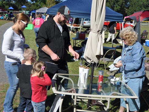 Laurel Hill resident Andrew Gronberg and his family receive boiled peanuts from Crestview resident Carol Coon at Gene Clary Park during the 2014 Laurel Hill Hobo Festival on Saturday.