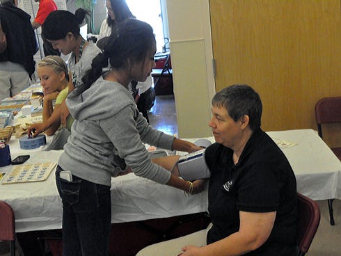 Katelyn Ramirez, 16, takes Hazel Holmes’ blood pressure during the Community Health Fair. Ramirez, 16, is a member of Crestview High School’s Students Together Reaching Instructional Diversity and Excellence program.