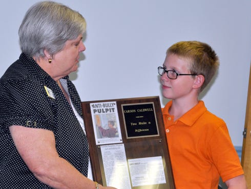 Sharlene Cox presents Carson Caldwell, 11, with a "You Make a Difference" plaque during a Thursday night Exchange Club of Crestview meeting at the Covenant Hospice building. Carson created Riverside Elementary School’s anti-bullying club.
