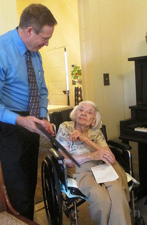Rev. Mark Broadhead speaks with 101-year-old Laurel Hill resident McDonald Campbell Aug. 1 during a church service at her home.