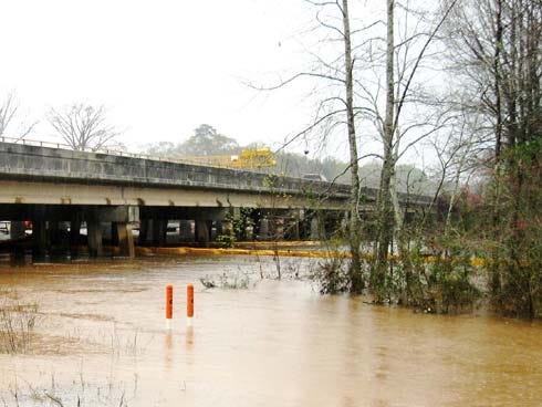 Floating turbidity barriers are deployed on the Yellow River at the U.S. 90 bridge construction site near Milligan to control erosion and contain possible fuel spillage when flooded equipment is removed.