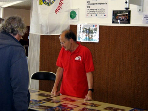Noirmoutier Sister City President René Relandeau stands beneath a Crestview city flag during a recent community activities forum on the French island.