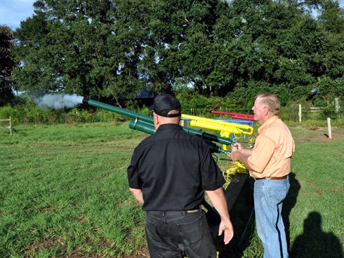 Crestview Rotary Club members Mike Carroll and Bill Barnhill practice firing a corn cannon near the Baker corn maze. The cannons and maze will open to the public this weekend.