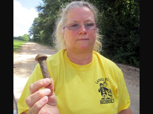 Hazel Harper displays a bolt that she found on Davis Road. The county has replaced five of her tires due to debris in the fill rocks.