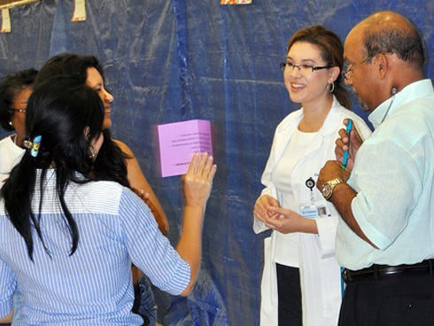 Doctors Anacani Fonseca and Joseph Peter speak with a family during last year’s No Child without Health Care Fair. This year’s fair goes is 9 a.m. to 2 p.m. Saturday at Crestview High School.