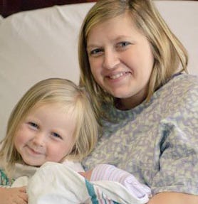 Kensie Holcomb joins her mother, Emily, in holding newborn Jacob. The baby will require additional surgery after being diagnosed with Hirschsprung’s disease, an abdomen disorder.