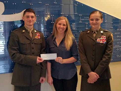 Lauren Walls, Children in Crisis volunteer and events director, center, receives a $500 check from Emerald Coast Young Marines Sgt. Ashton Norman, left, and SSgt. Michaela Cantwell. The funds will be used to help provide a home, food, clothing and care to more than 100 at-risk children who will stay at the CIC Children's Neighborhood home this year.
