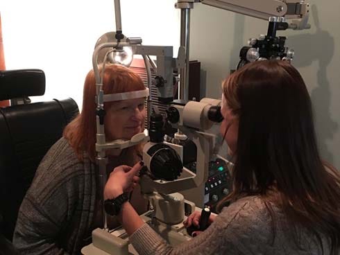 Dr. Alexandra Schuette examines Carol Hassett's eyes Dec. 24 at Gulf Coast Vision Center in Crestview. Hassett is Lifepoint Church's soup kitchen coordinator.