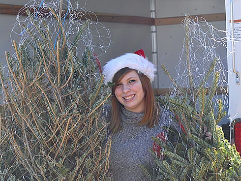 Reba Fitzpatrick, 16, stands next to two of 23 Frasier firs that Lowe's Home Improvement donated. Reba and her father, David, collected the trees for Sharing and Caring in Crestview, which donated them to lower income families.