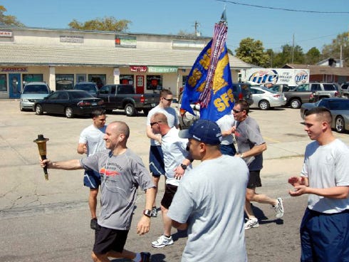 Participants in a recent Law Enforcement Special Olympics Torch Run carry the torch along the route.