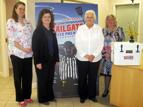 Trustmark Bank Crestview branch tellers Michelle Walters and Dianne Ball, left, and branch manager Laurin Wheelock, right, present customer Dorothy Boles with a new Yeti cooler.