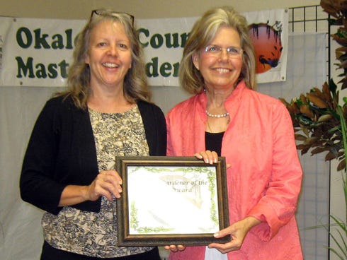 Okaloosa County Master Gardeners President Stacey Taylor receives recognition as Master Gardener of the Year from county commissioner-elect Carolyn Ketchel.