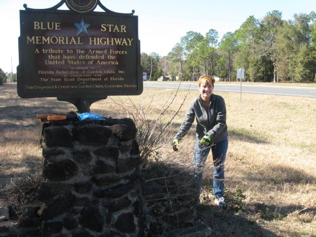Dogwood Garden Club member Carol Strom spends a sunny winter's day cleaning around the U.S. Highway 90 Blue Star Memorial marker west of Crestview.